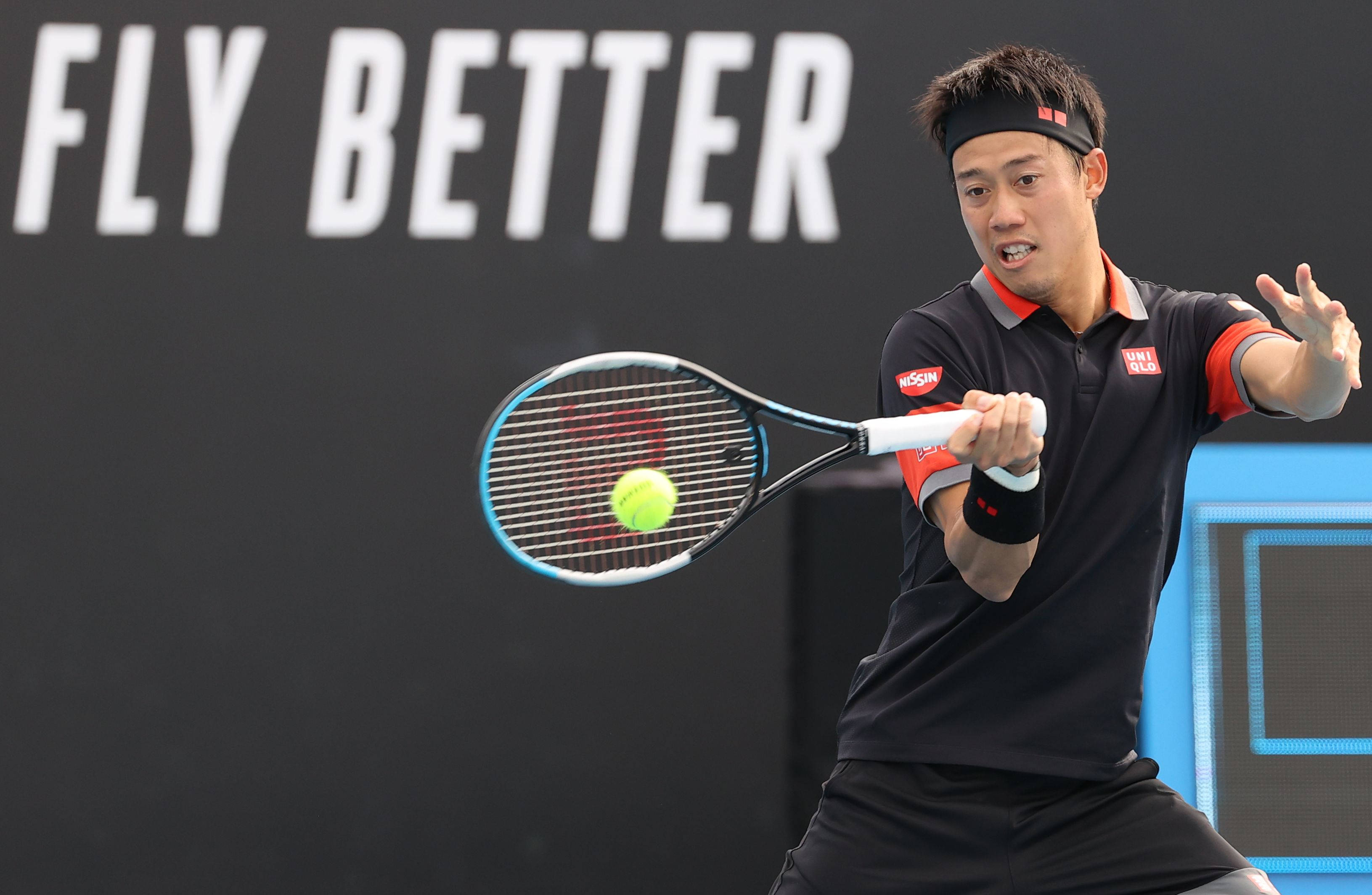 Australian Open 桌布 壁紙 — 一名身穿黑色裝備的男網球選手揮動球拍，將亮黃色的球擊向帶有白色文字的深色牆壁。
