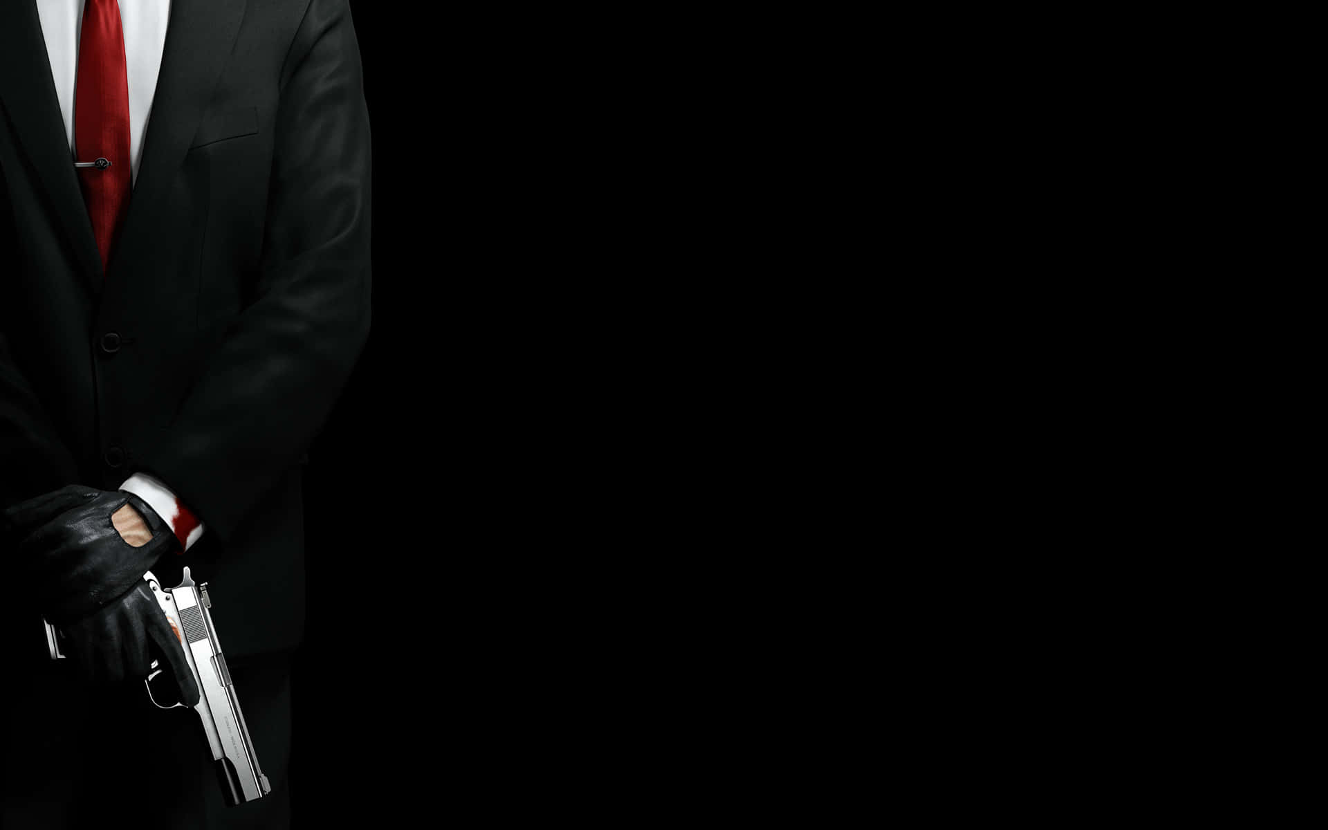 Hitman Absolution 桌布 壁紙 — 一名身穿黑色西裝、打紅色領帶的男子，在純黑背景前手持銀色手槍。
