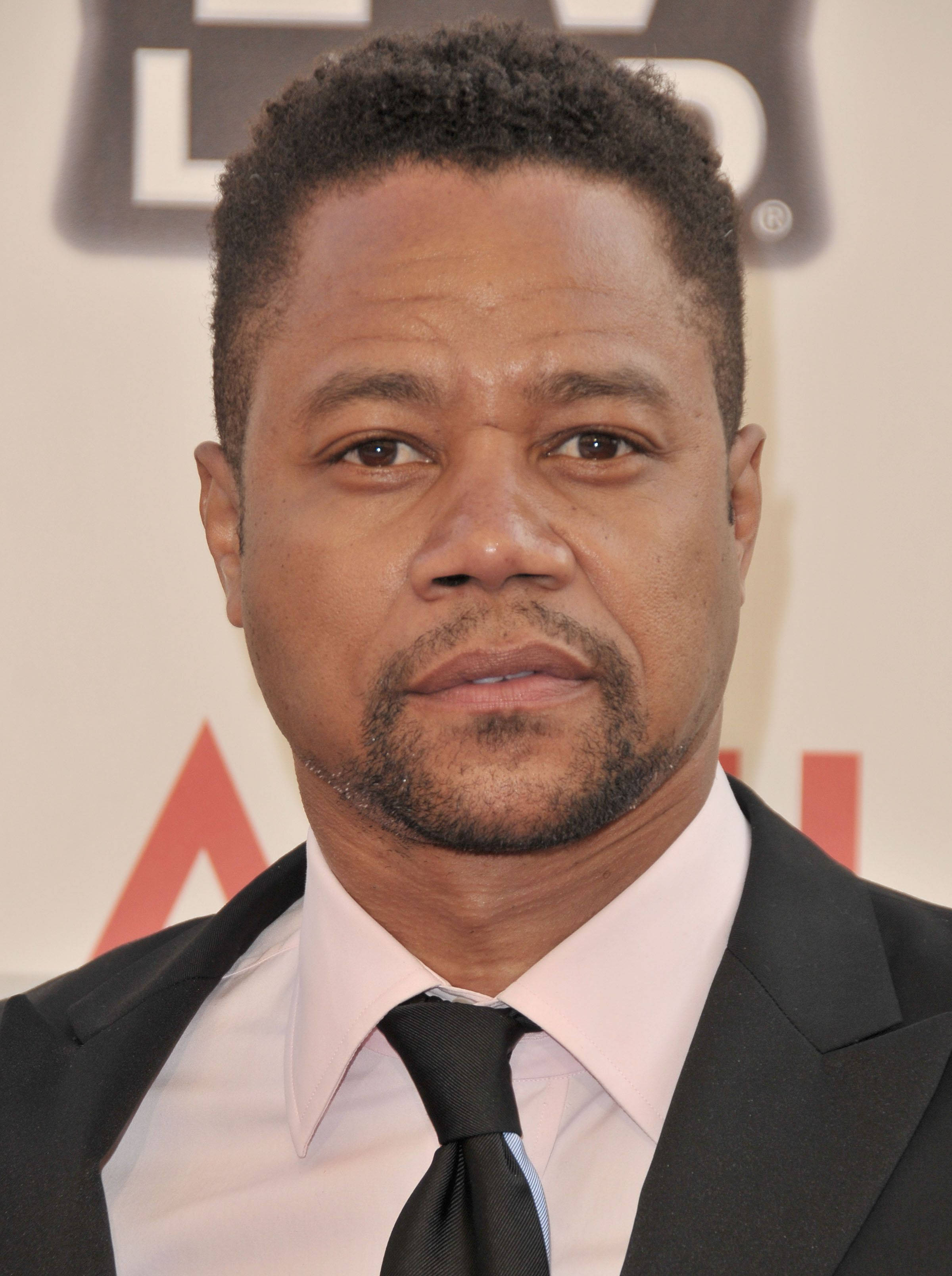 actor 桌布 壁紙 — 一名身穿黑色西裝和領帶的男士，在模糊的活動背景下的特寫肖像。