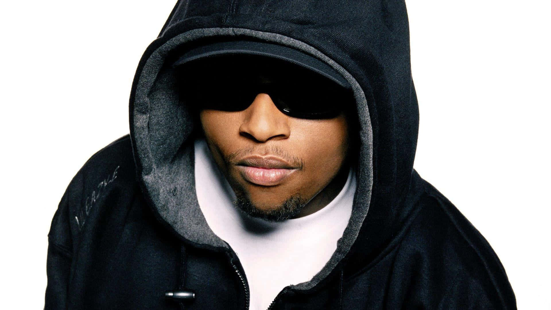 Eazy E 桌布 壁紙 — 一名身穿黑色連帽衫和太陽眼鏡的男子，在純白背景下強烈凝視。