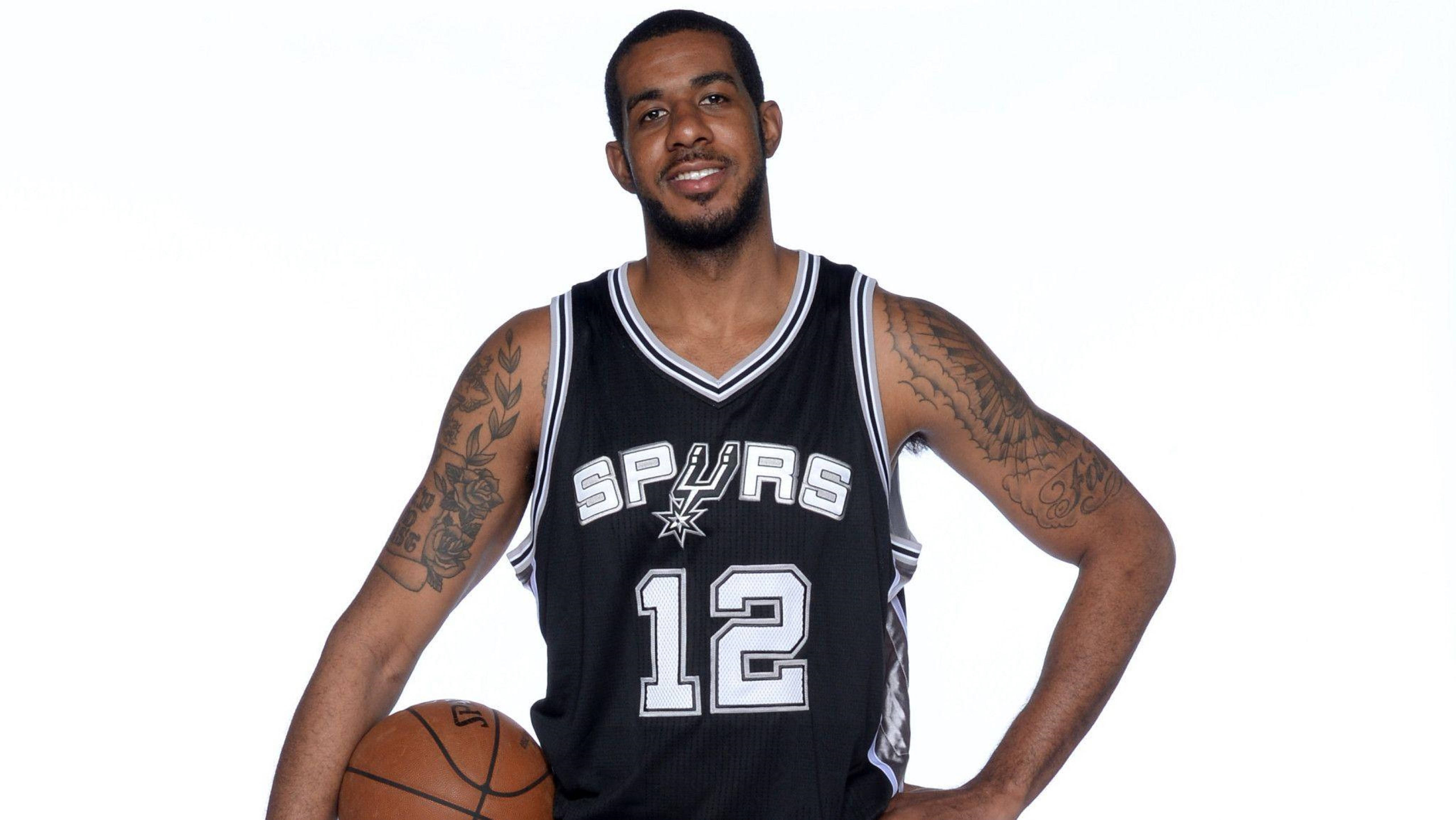 Lamarcus Aldridge 桌布 壁紙 — 一名身穿黑色馬刺球衣、號碼12的籃球運動員，在純白色背景前拿著一個籃球。