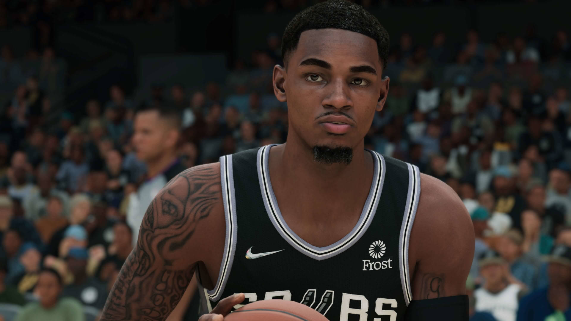 Dejounte Murray 桌布 壁紙 — 一名身穿黑色馬刺球衣的籃球運動員，手臂上可見刺青，在模糊的人群背景下持球。