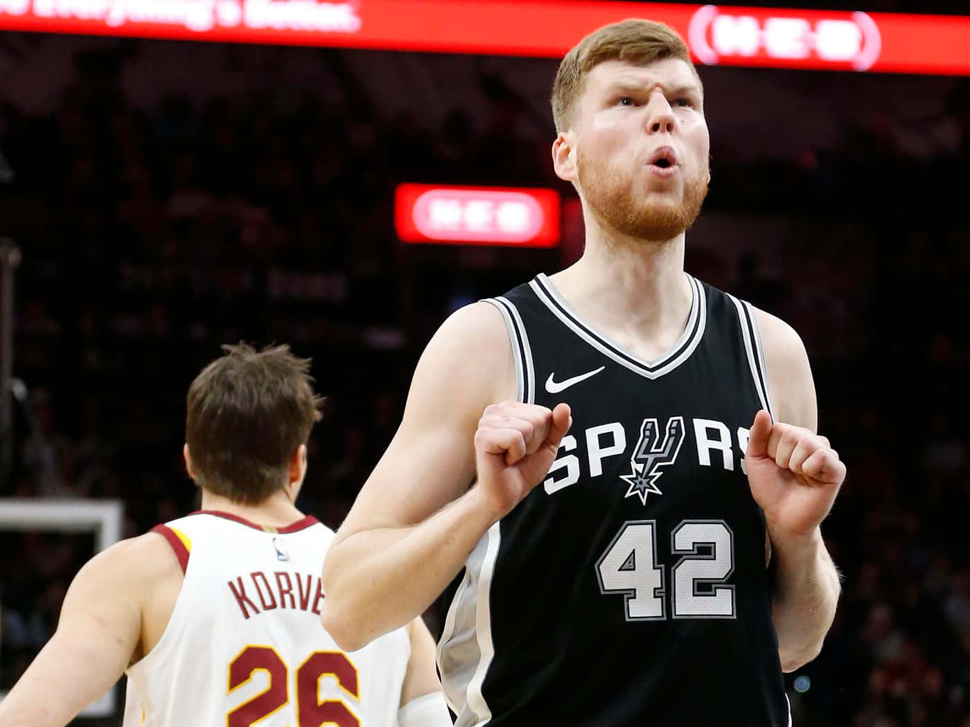 NBA 桌布 壁紙 — 一名身穿黑色馬刺隊42號球衣的籃球運動員在場館燈光下比賽時握拳慶祝。