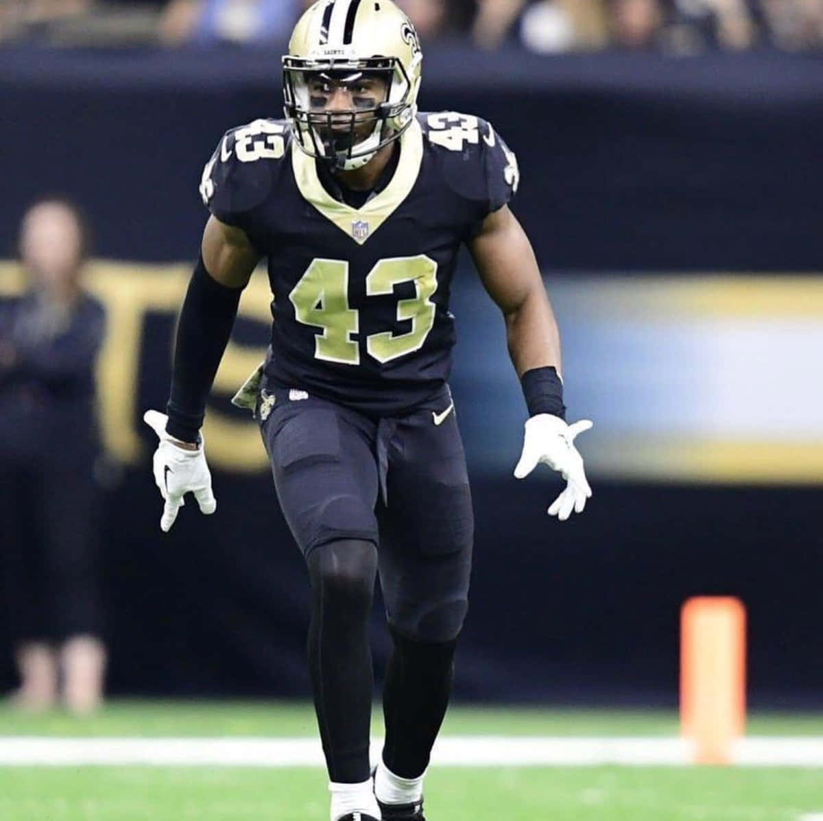 Marcus Williams 桌布 壁紙 — 一名身穿黑金色球衣、號碼43的足球員在球場燈光下於綠色場地上奔跑。