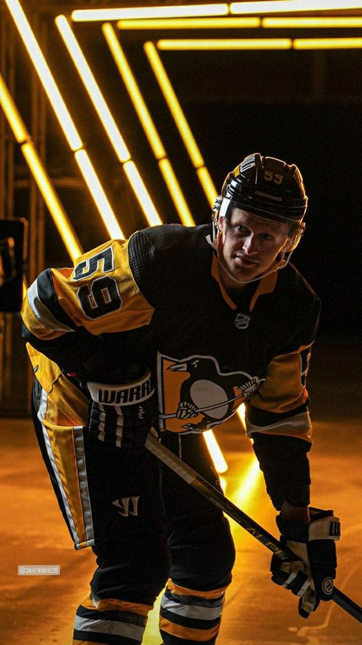 hockey 桌布 壁紙 — 一名身穿黑金色球衣的曲棍球運動員在發光的黃色霓虹燈下激烈地蹲下。