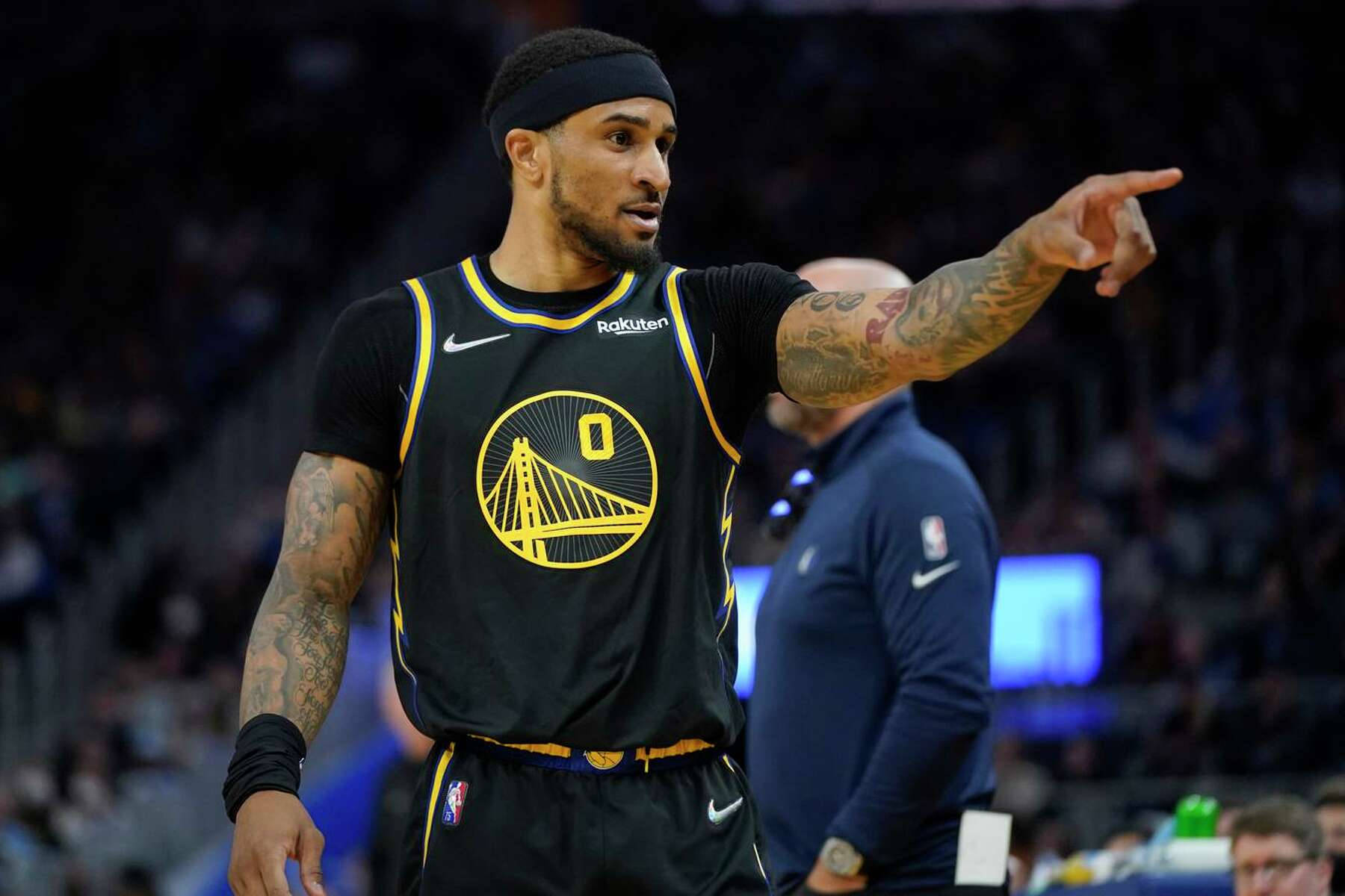 NBA 桌布 壁紙 — 一名身穿黑黃球衣、手臂有刺青的籃球運動員在明亮的場館燈光下，在比賽中專注地指著。