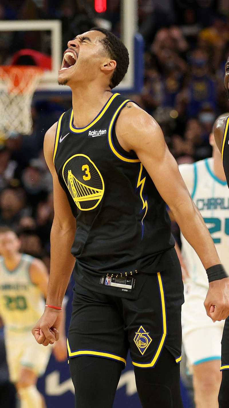 籃球運動員張開嘴巴、握緊拳頭在球場上慶祝勝利。