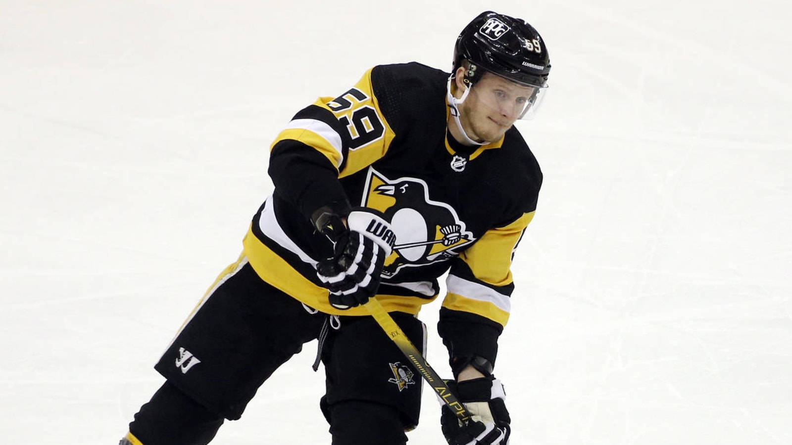 hockey 桌布 壁紙 — 一名身穿黑黃色球衣的曲棍球運動員在冰上低蹲，專注地握著球棍比賽。