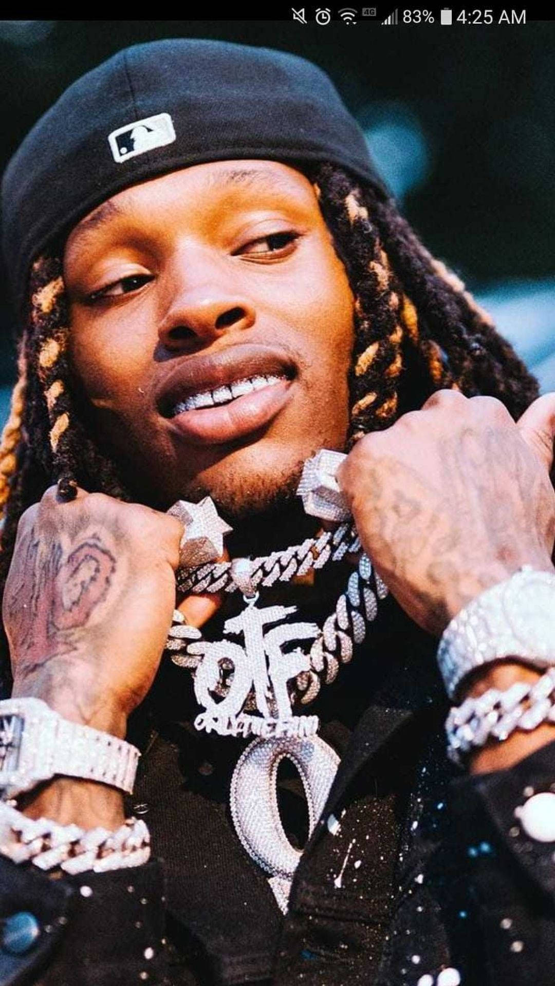 Lil Durk 桌布 壁紙 — 一名辮子男子戴黑色帽子及閃亮鑽石首飾，背景模糊的特寫肖像。