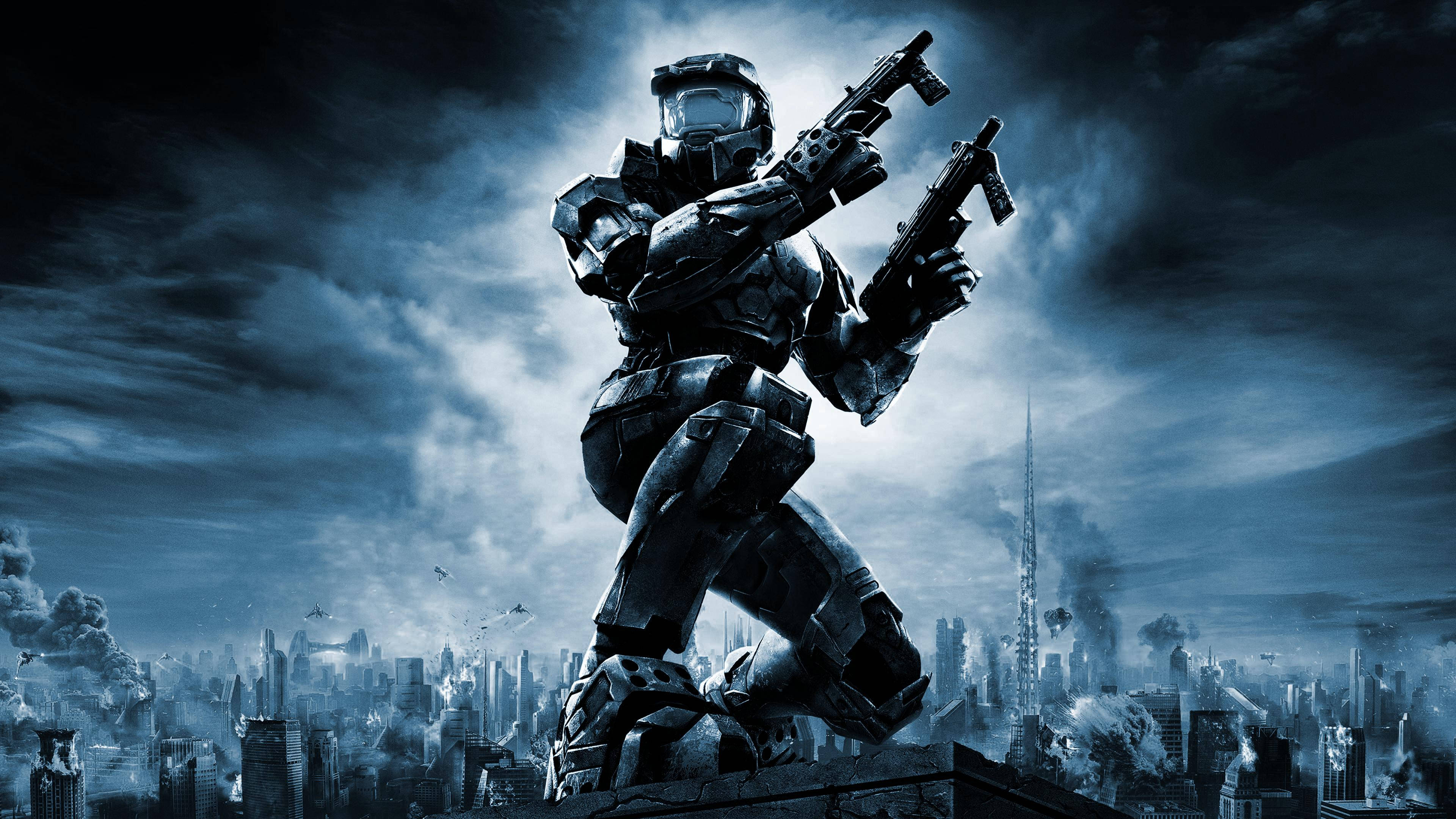 Master Chief 桌布 壁紙 — 一名重裝士兵站在廢墟城市景觀之上，在風暴藍天下手持兩件武器。