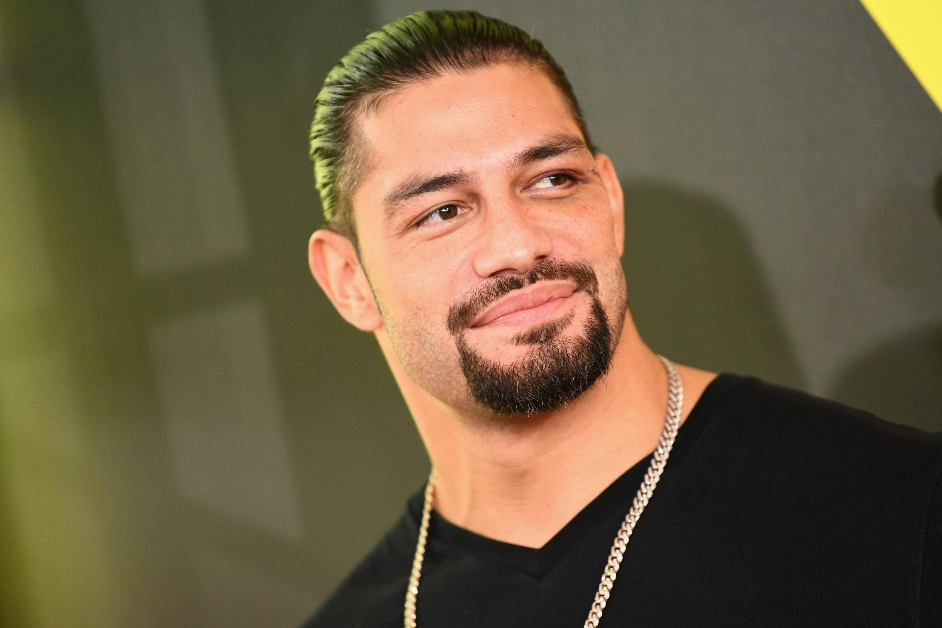 Roman 桌布 壁紙 — 一名頭髮和鬍鬚染成綠色的男士特寫肖像，身穿黑色襯衫和銀色鏈條。