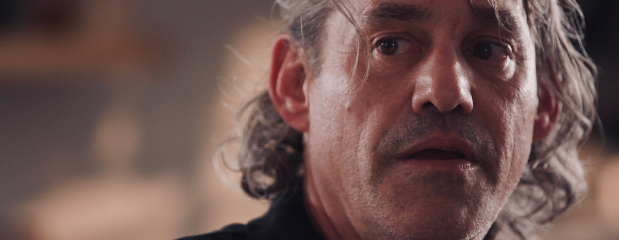 Nicholas Brendon 桌布 壁紙 — 一名頭髮花白、眼神銳利的男子，表情嚴肅地望向鏡頭外的特寫。