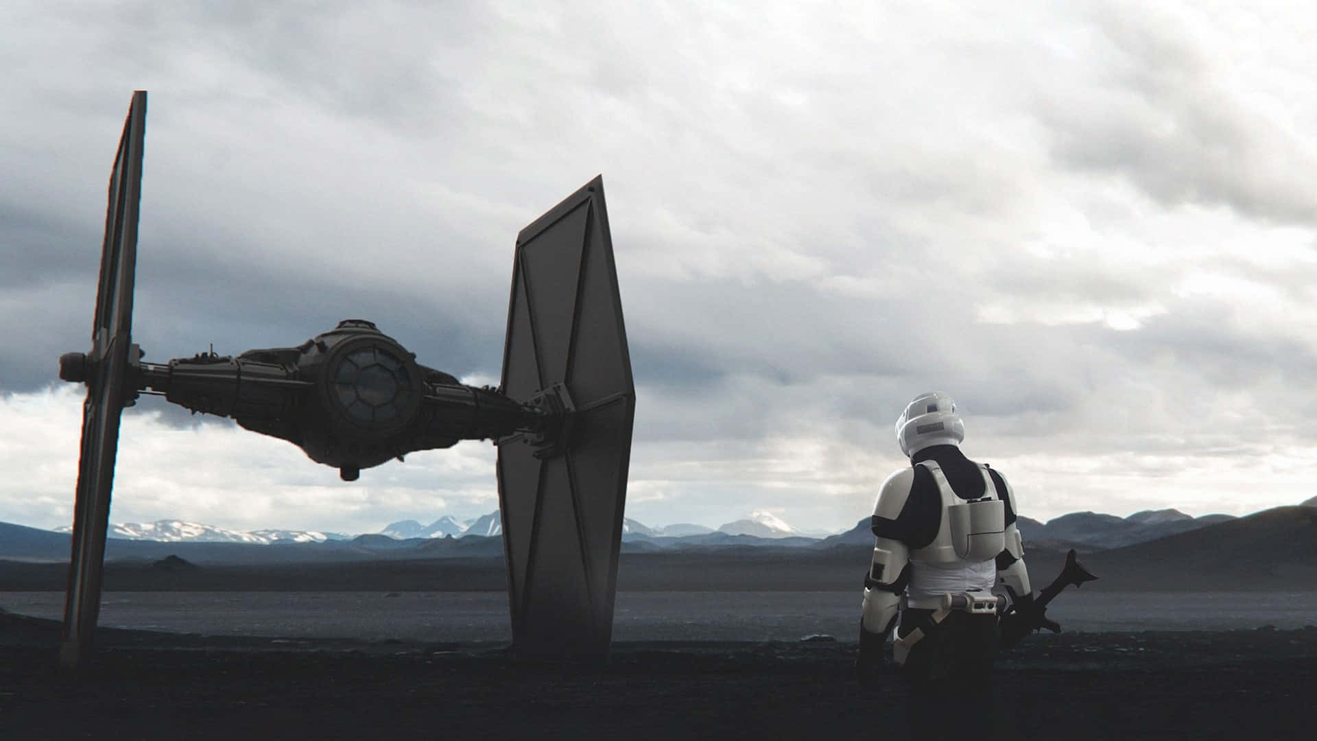 Imperial Army 桌布 壁紙 — 一名風暴兵站在一架TIE戰鬥機旁，位於一個貧瘠的星球上，有積雪覆蓋的山脈，天空多雲。