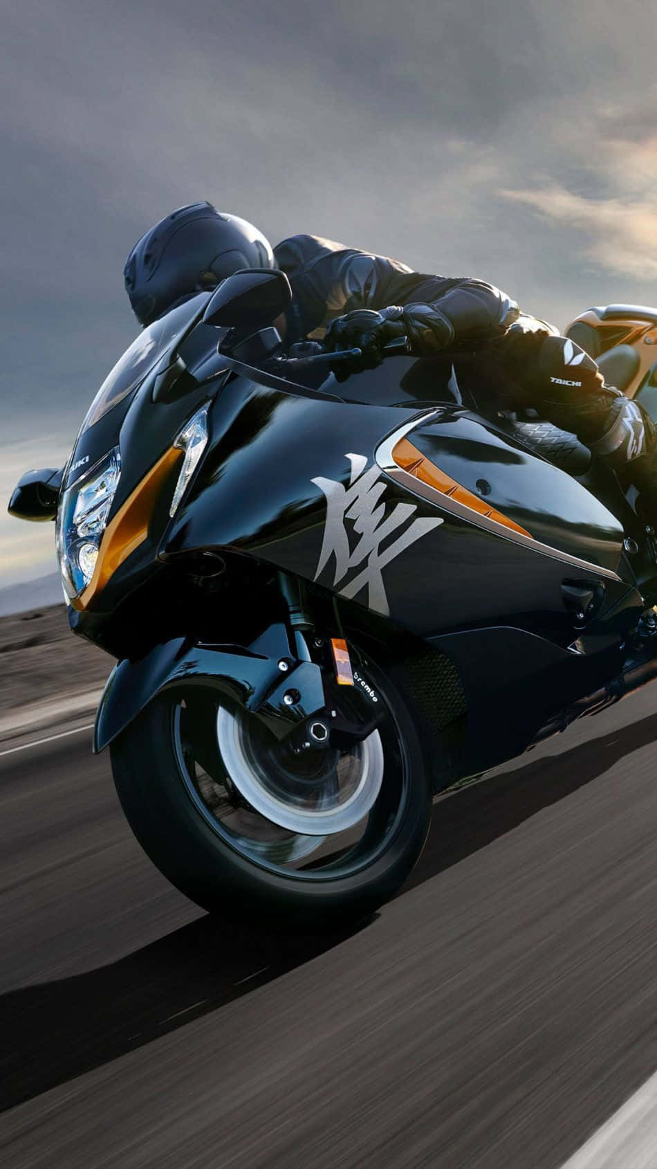 Superbike 桌布 壁紙 — 一名騎士在戲劇性的多雲天空下，騎著一輛時尚的黑色和橙色運動機車傾斜入彎。