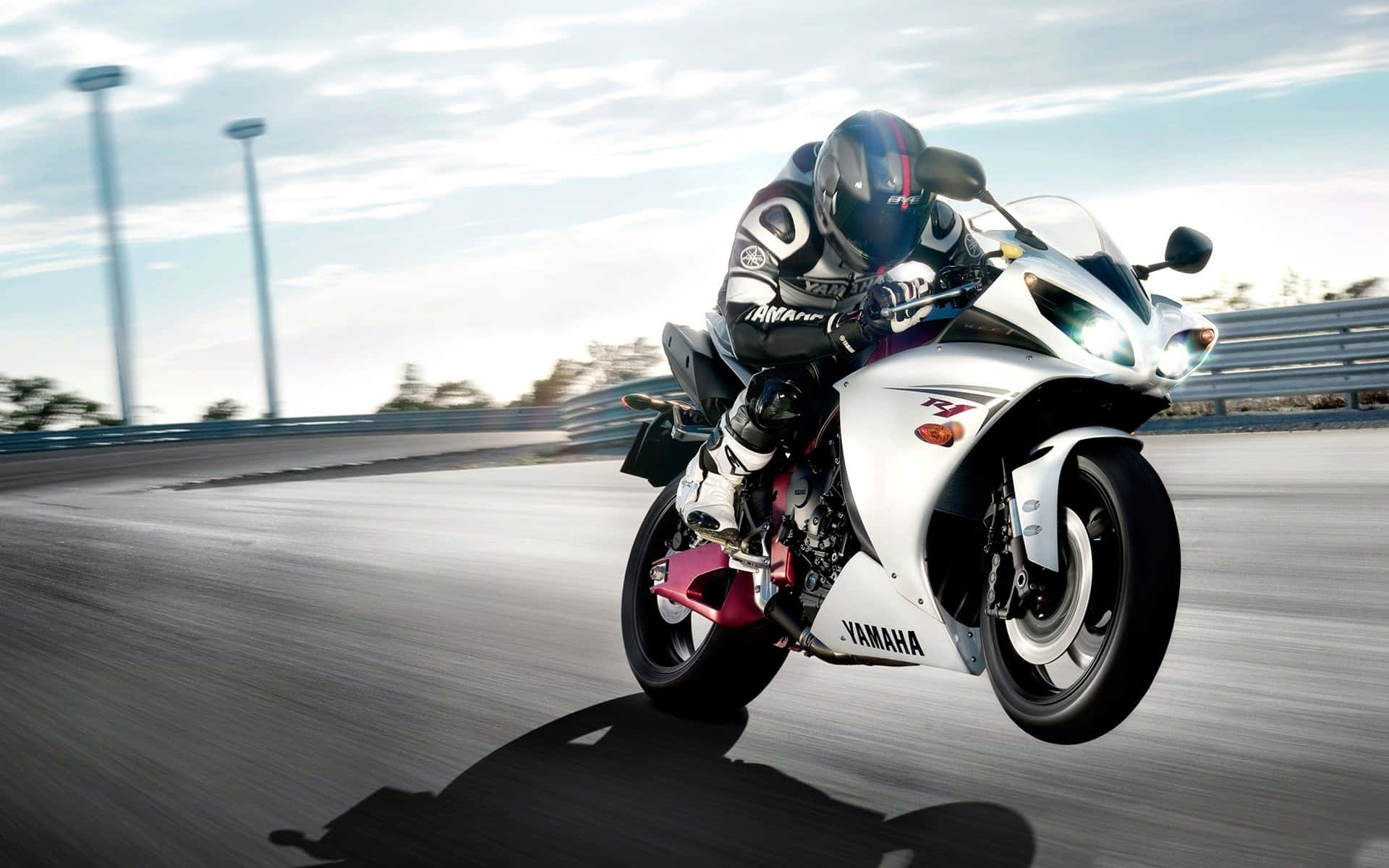 Superbike 桌布 壁紙 — 一名騎士在明亮的天空下，在賽道上騎著白色Yamaha跑車傾斜入彎。