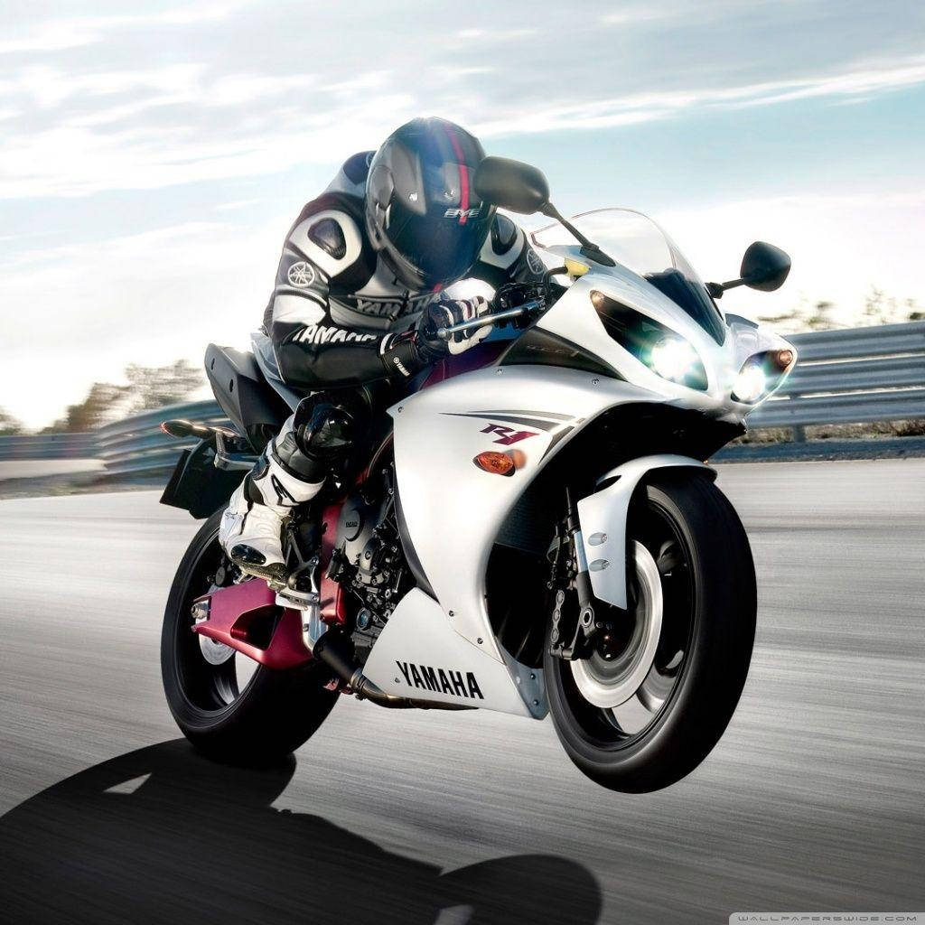 4K bike 桌布 壁紙 — 一名騎士在明亮的天空下，在賽道上騎著白色Yamaha R1機車傾斜入彎。