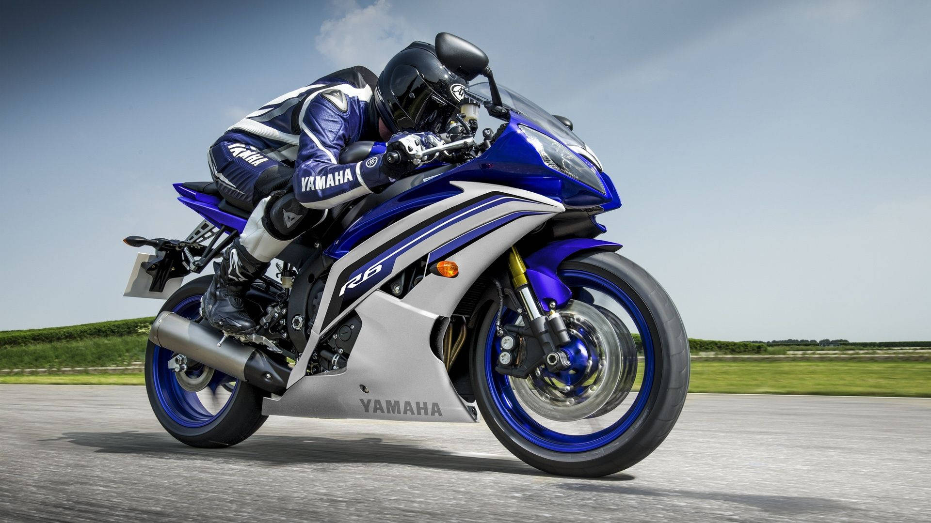 摩托車騎士在鋪砌道路上騎著藍色Yamaha R6傾斜入彎。 — 機車 壁紙