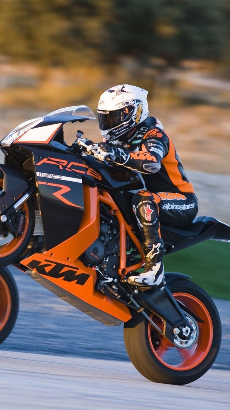 ktm rc 200 桌布 壁紙 — 一名騎士在賽道上騎著鮮橙色KTM RC8機車，傾身入彎，背景動態模糊。