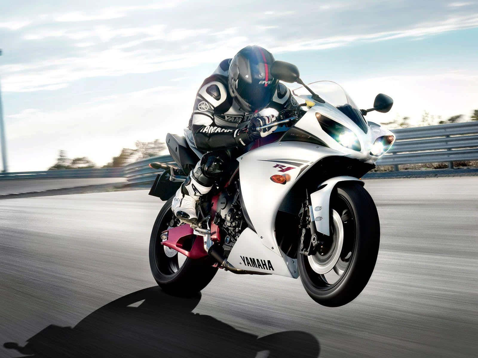 Rider 桌布 壁紙 — 一名騎士在陽光明媚的賽道上騎著白色Yamaha跑車，傾斜入彎，帶有模糊動態效果。