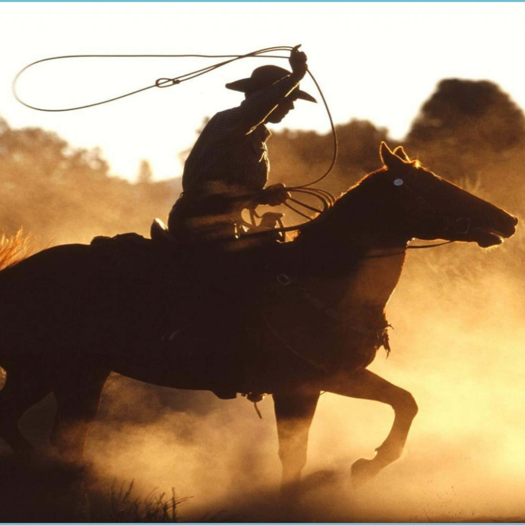 Western Cowboy iPhone 桌布 壁紙 — 一名騎著奔騰馬匹的牛仔，在金色夕陽塵雲中揮舞套索。