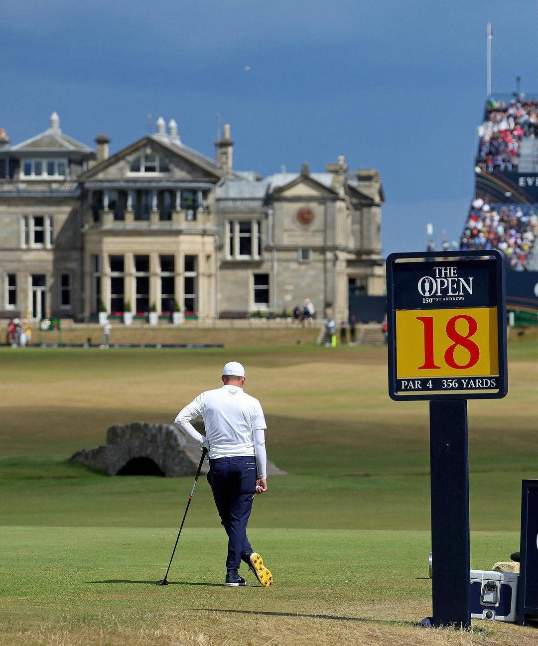 Scotland 桌布 壁紙 — 一名高爾夫球手在英國公開賽中走向第18洞果嶺，背景是宏偉的石造會所和座無虛席的看台。