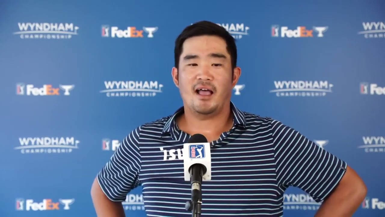 Man 桌布 壁紙 — 一名高爾夫球手在藍色品牌背景的新聞發布會上對著麥克風發言。