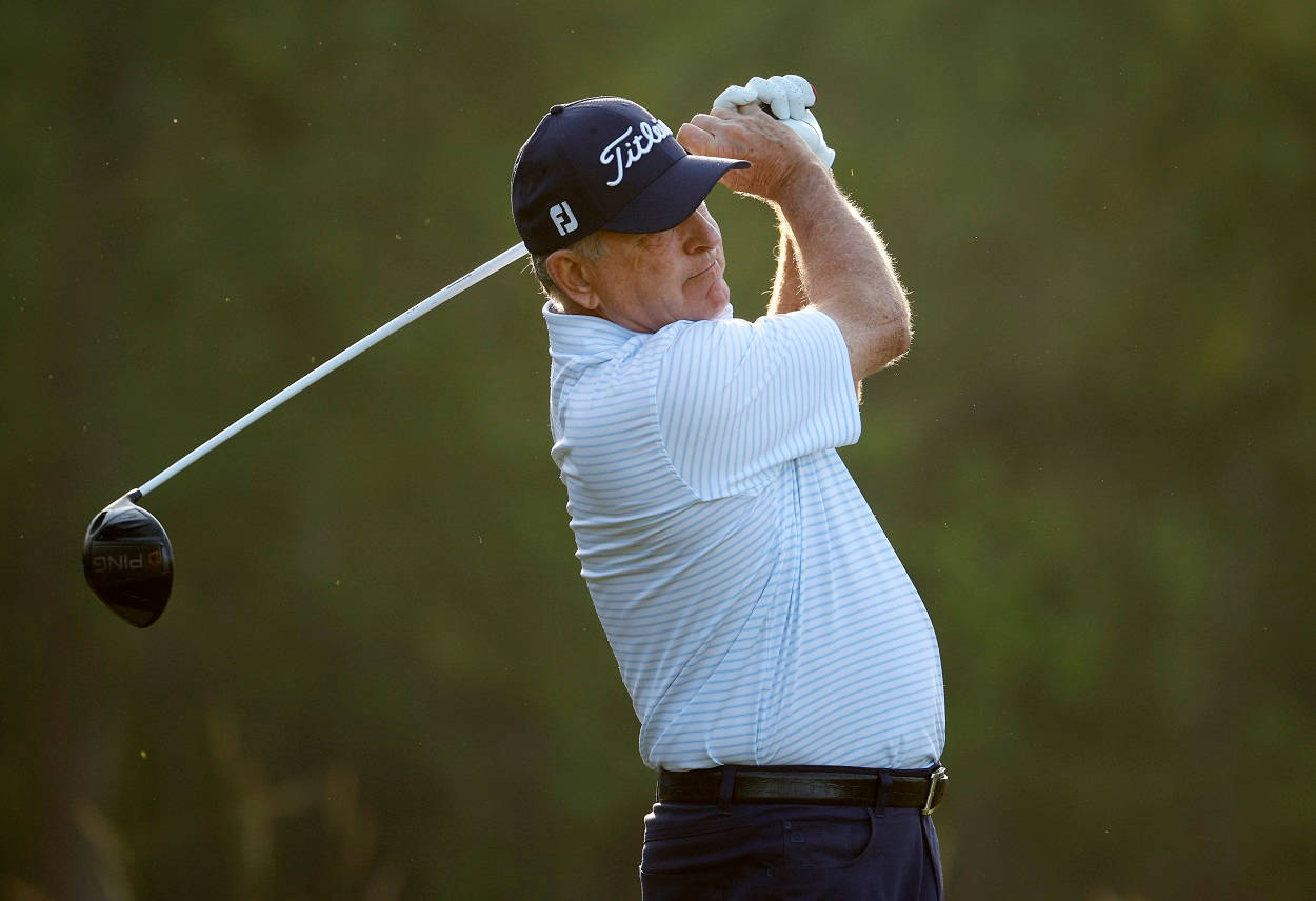 高爾夫 桌布 壁紙 — 一名高爾夫球手正在揮桿，戴著 Titleist 帽子和條紋襯衫，背景是模糊的綠色。