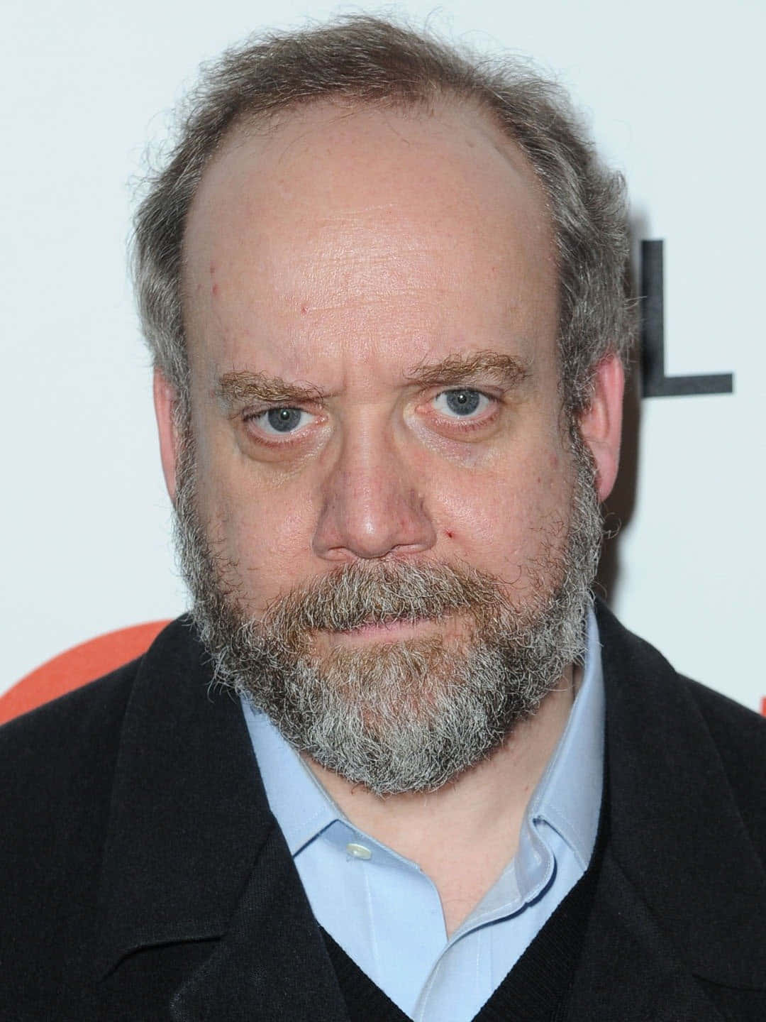 Paul Giamatti 桌布 壁紙 — 一名鬍鬚灰白、藍眼睛深邃的男士特寫肖像，身穿深色外套內搭淺藍色襯衫。