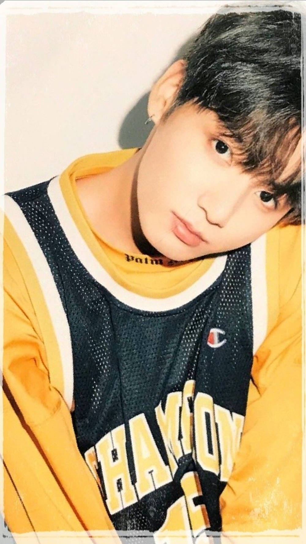 BTS 桌布 壁紙 — 一名黑髮年輕男子靠近鏡頭，身穿黃色和黑色Champion籃球球衣，內搭黃色襯衫。