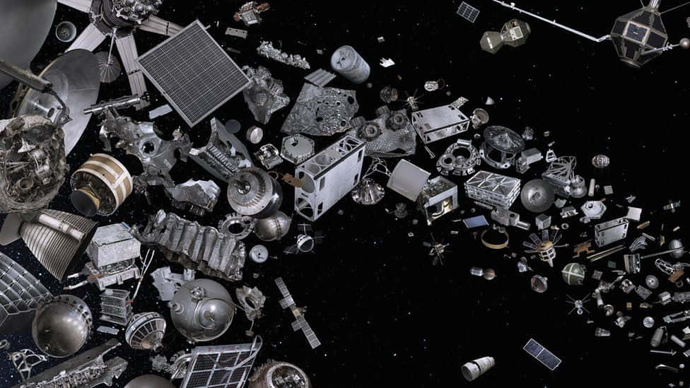 Space Debris 桌布 壁紙 — 一團密集的金屬太空碎片漂浮在佈滿星星的黑色虛空中，展示出破損的衛星和火箭零件。