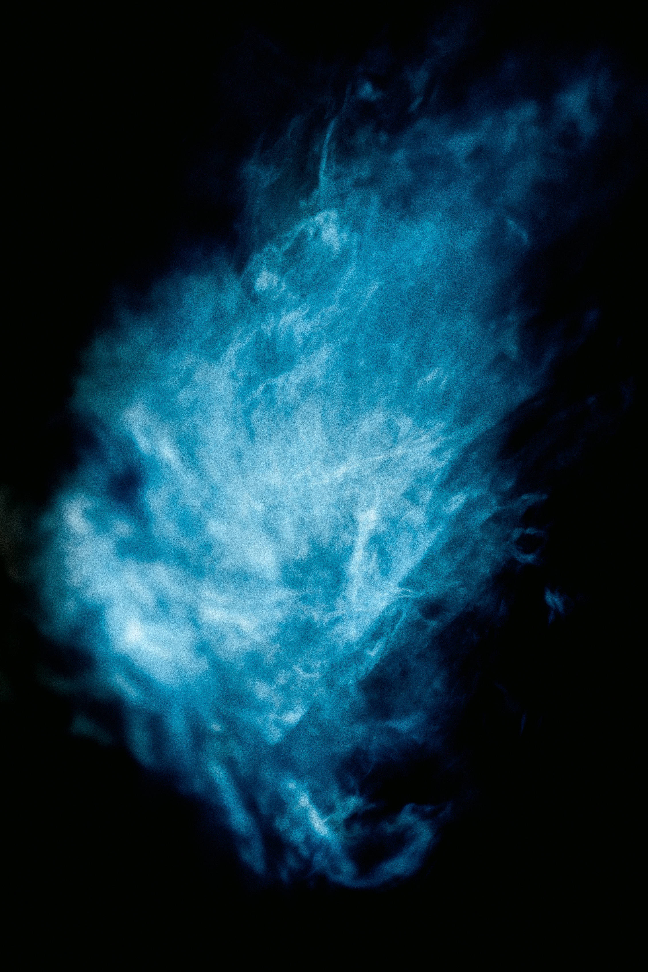 Dark Blue iPhone 桌布 壁紙 — 一團旋轉的電藍色煙霧在純黑色背景上翻騰，營造出一種空靈而神秘的氛圍。