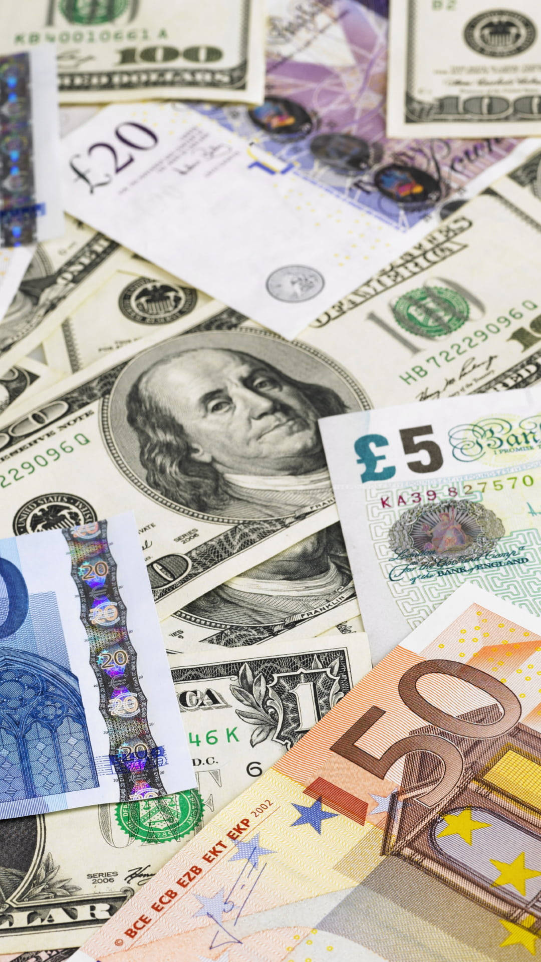money iPhone 桌布 壁紙 — 一團混亂的全球貨幣，包括美元、英鎊和歐元，展示多樣的鈔票設計和安全特徵。
