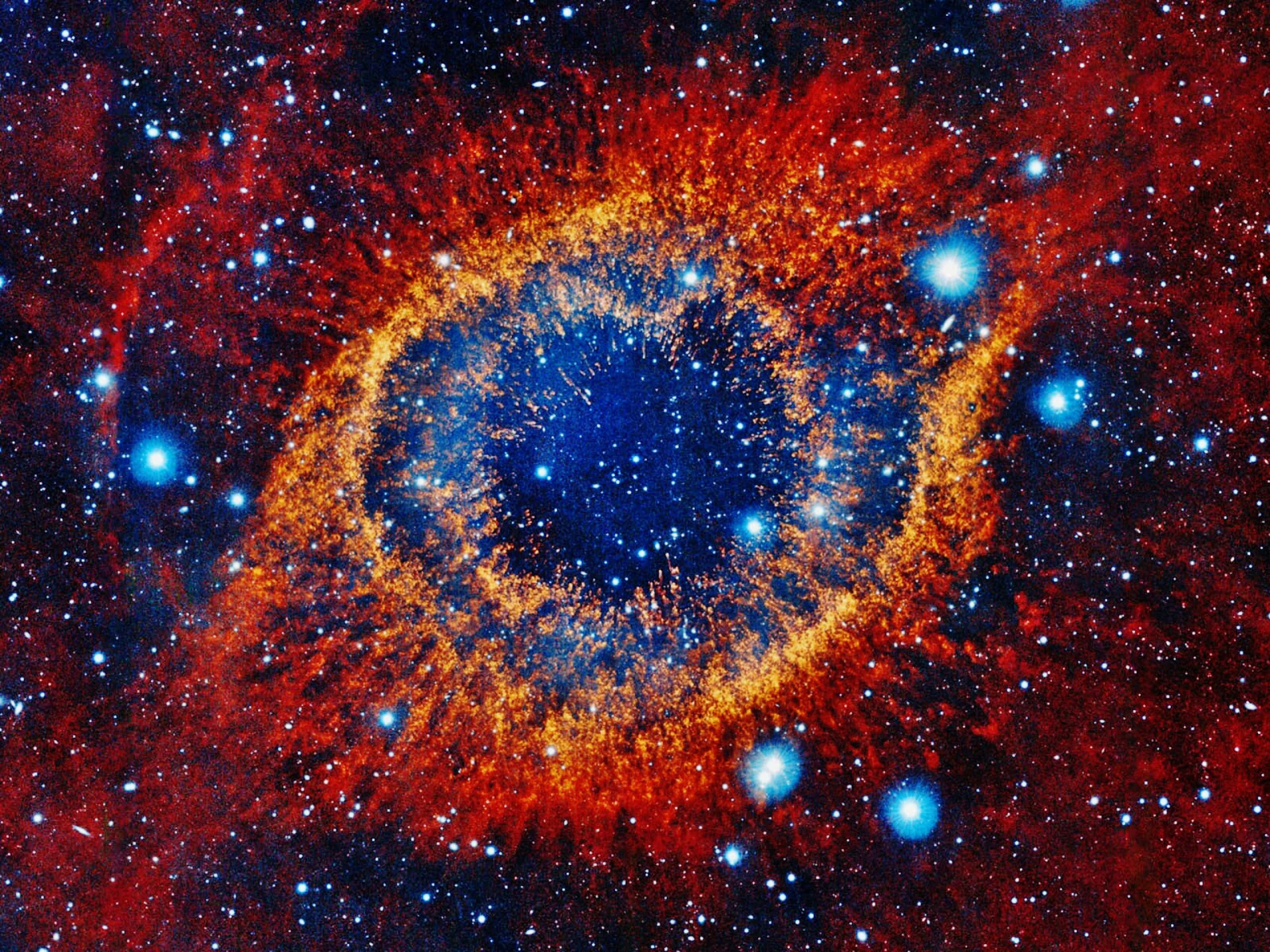 Planetary Nebula 桌布 壁紙 — 一團火橙色和深藍色氣體組成的宇宙之眼，在星場中環繞著一個黑暗中心。