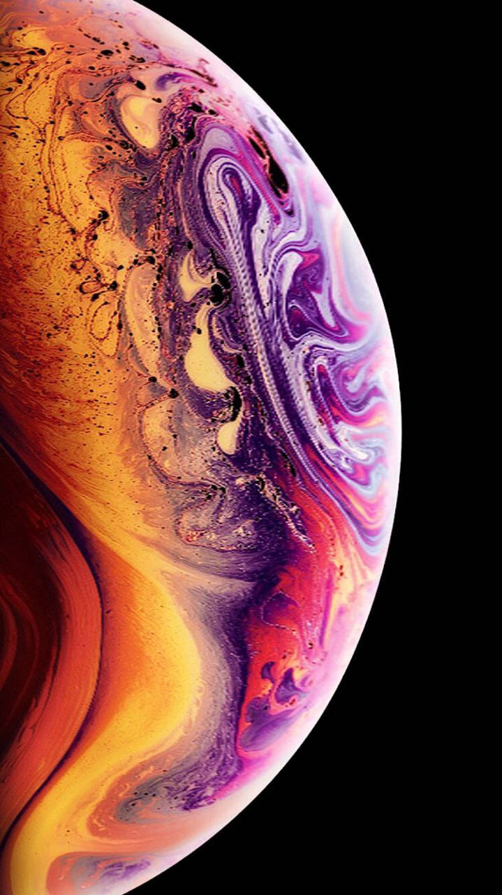 iPhone 桌布 壁紙 — 一團由橙色、紫色和金色組成的旋轉宇宙星雲，在虛無的黑色背景上繪出彎曲的天體球體。