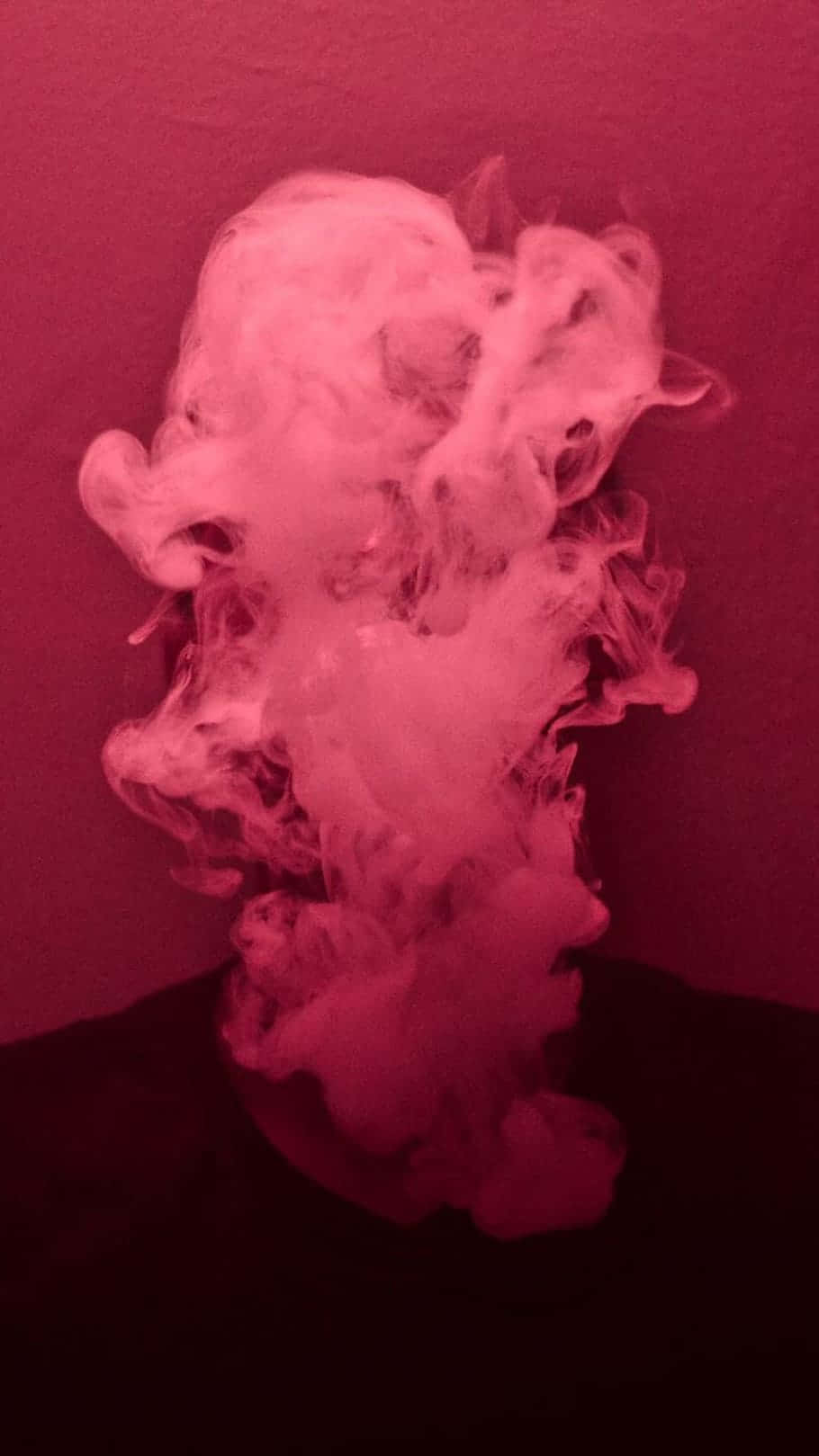 Pink Smoke 桌布 壁紙 — 一團粉紅色煙霧旋轉升起，在深洋紅色背景襯托下顯得格外戲劇化。