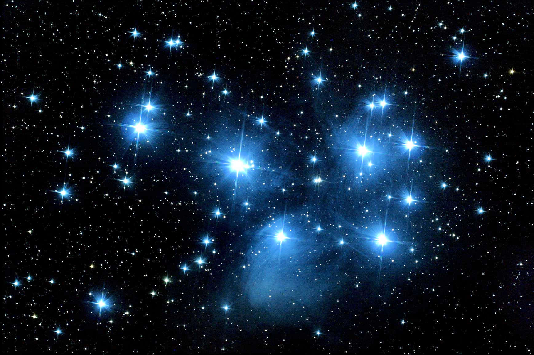 Star Cluster 桌布 壁紙 — 一團耀眼的藍色恆星在深邃的黑色宇宙虛空中閃爍，伴隨著微弱的星雲絲縷。