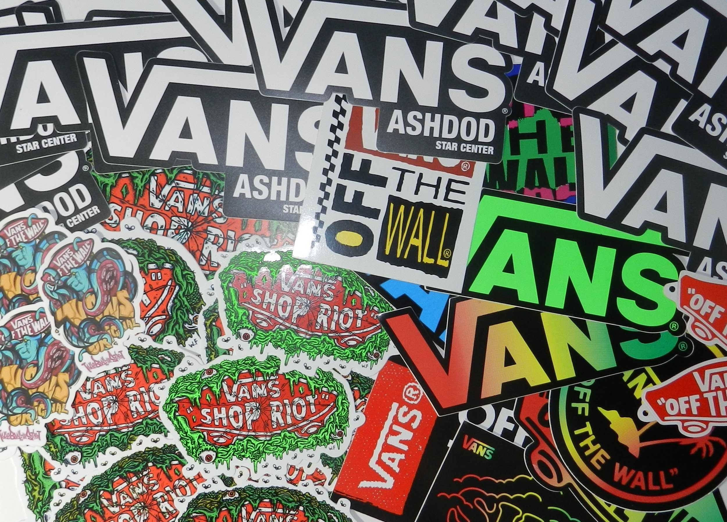 Vans Off The Wall 桌布 壁紙 — 一堆充滿活力、混亂的Vans品牌貼紙，上面有鮮明的標誌和色彩繽紛的圖案互相重疊。