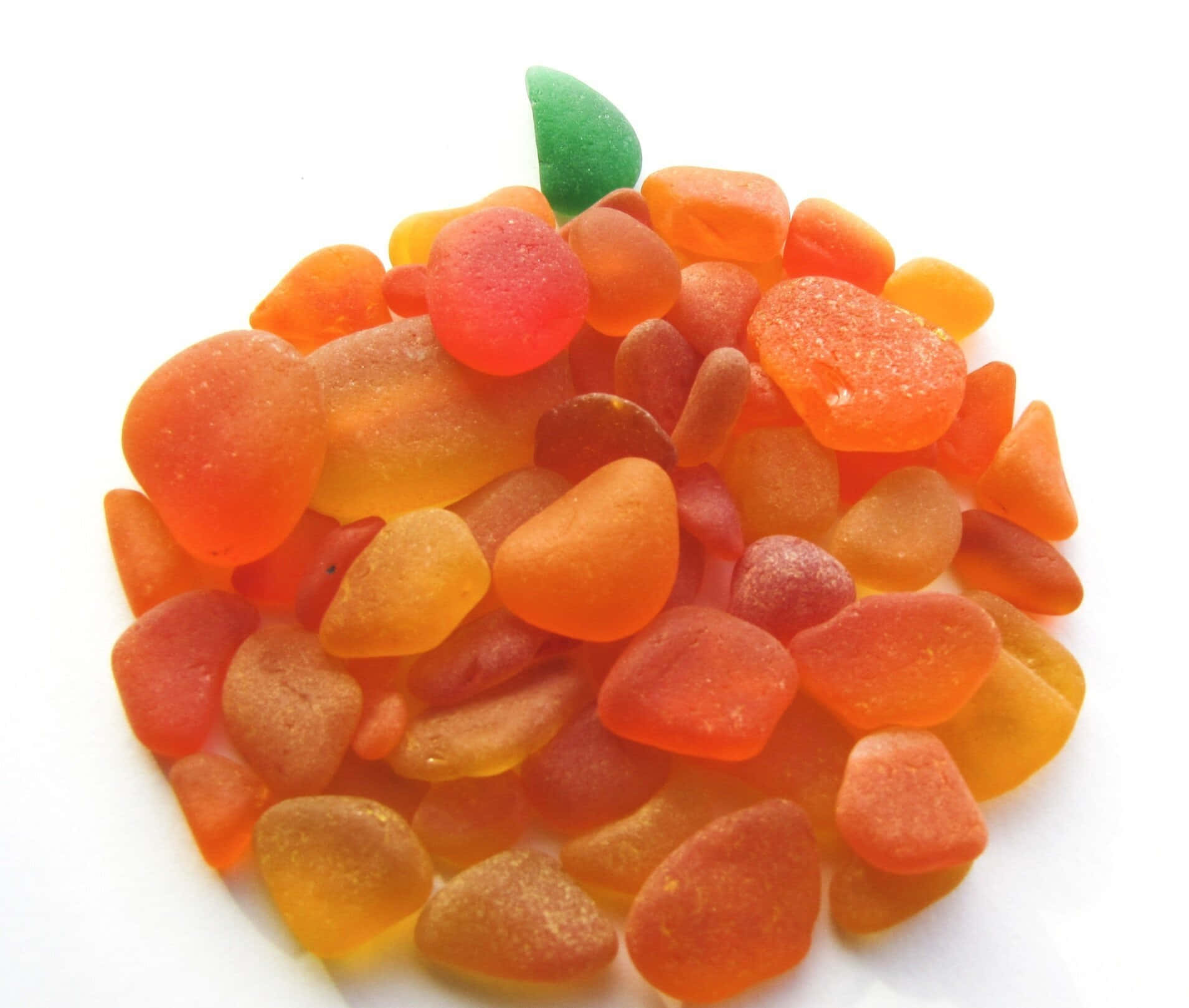 Sea Glass 桌布 壁紙 — 一堆充滿活力的半透明橙色和紅色海玻璃碎片，形狀像一個南瓜，頂部有一片綠葉。