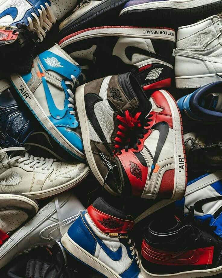 Sneaker 桌布 壁紙 — 一堆充滿活力的高筒運動鞋，採用大膽的紅、藍、白色，帶有可見的'AIR'品牌標誌和紅色鞋帶。