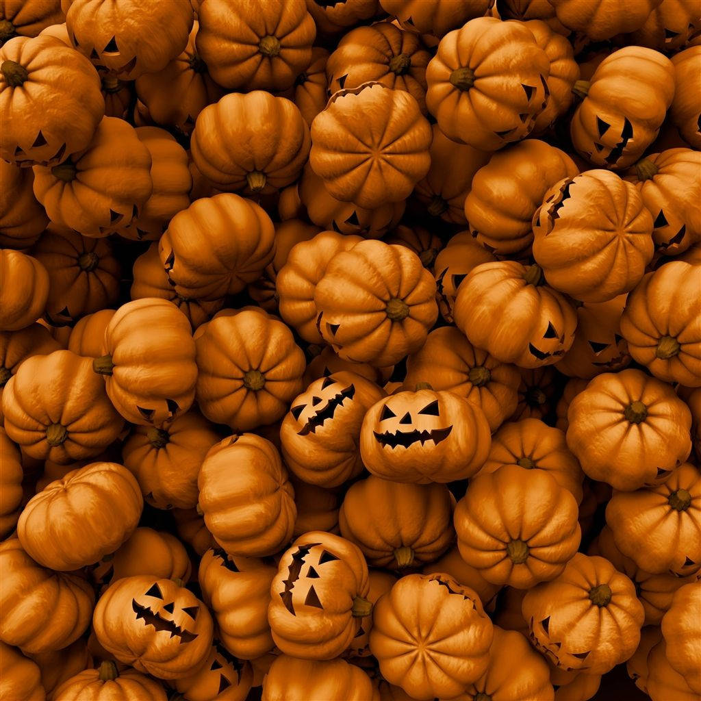 Halloween iPad 桌布 壁紙 — 一堆密密麻麻的橙色南瓜，雕刻著傑克南瓜燈的臉，在萬聖節展示中溫暖地發光。