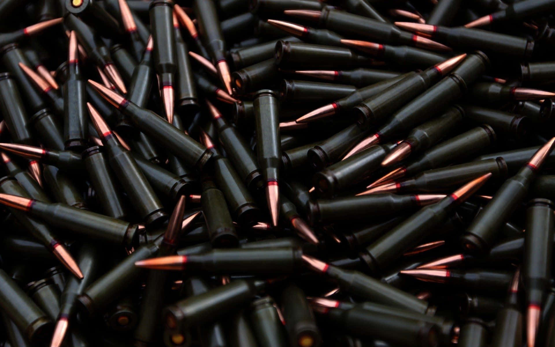bullet 桌布 壁紙 — 一堆密集的黑色步槍子彈，帶有銅質彈頭，混亂地散落在特寫中。