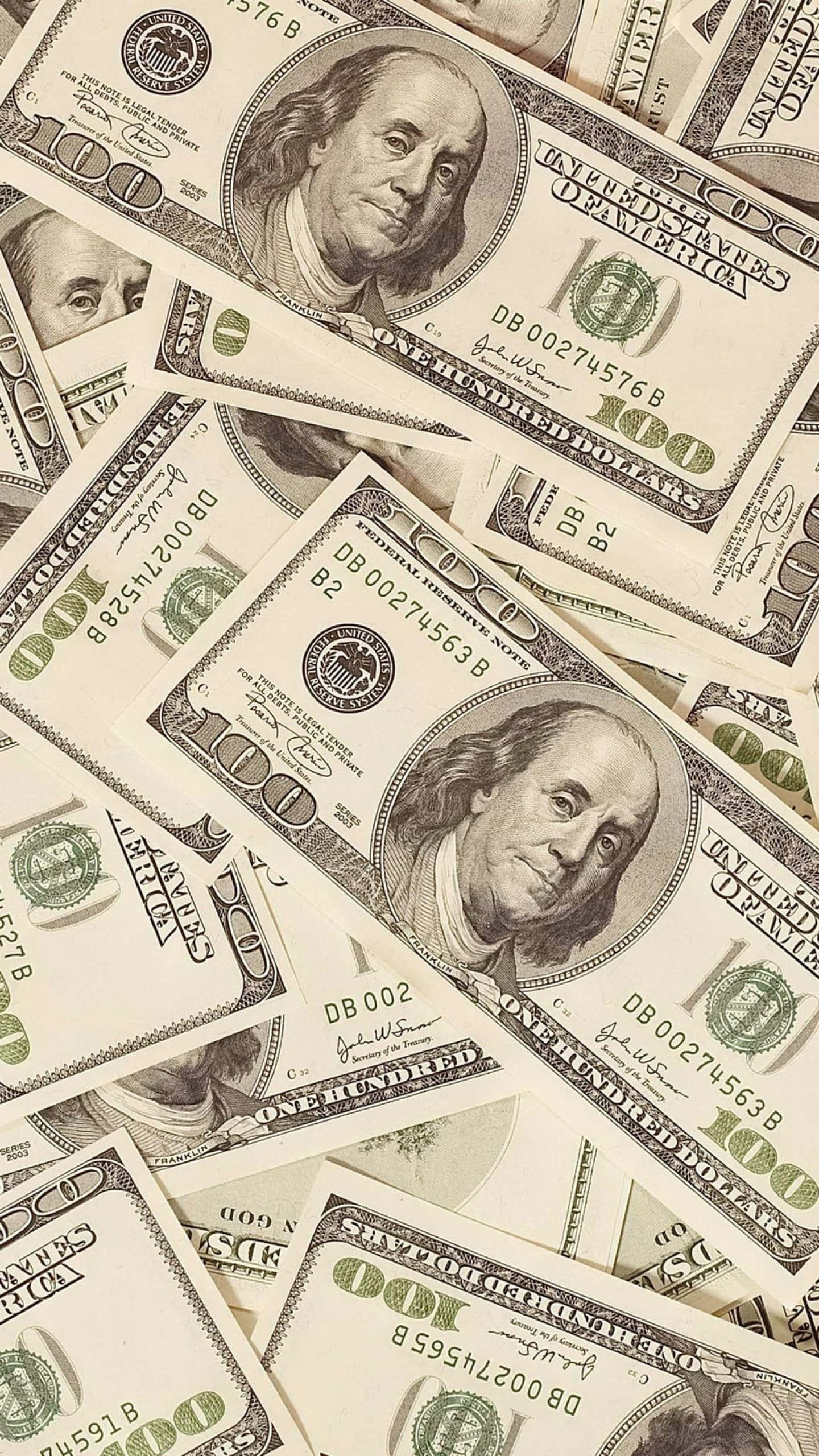 金錢 桌布 壁紙 — 一堆密集重疊的百元美鈔，上面有班傑明·富蘭克林的肖像和綠色墨水細節。