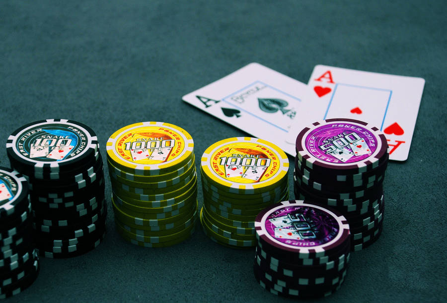 Poker 桌布 壁紙 — 一堆彩色籌碼和兩張Ace牌放在深綠色氈面賭桌上。