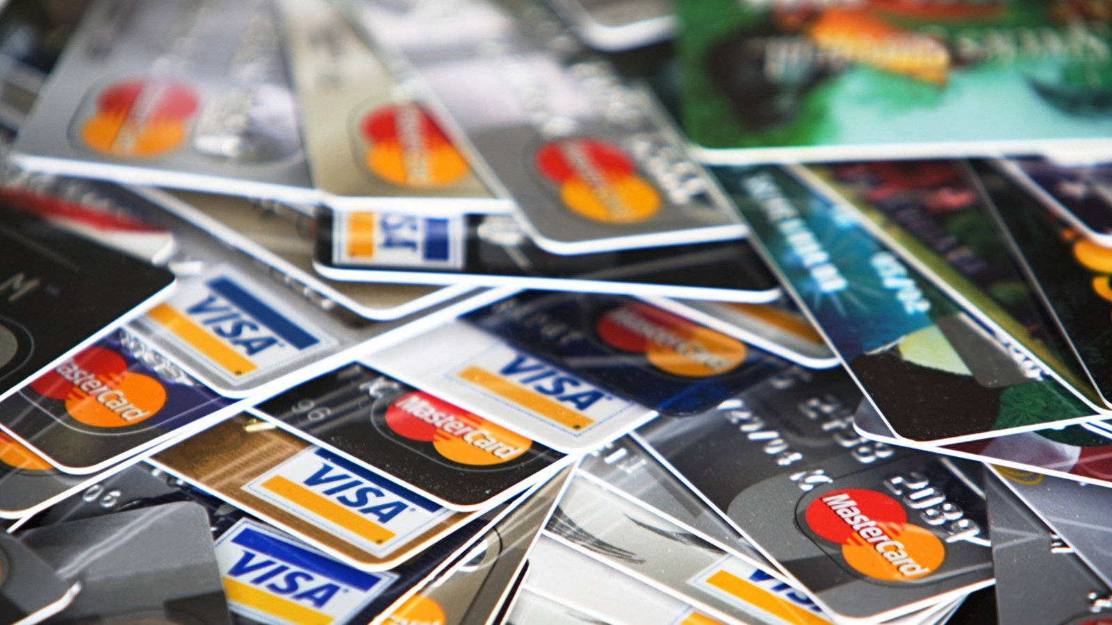 Credit Card 桌布 壁紙 — 一堆散落的信用卡特寫，Visa 和 Mastercard 標誌清晰對焦，背景模糊。