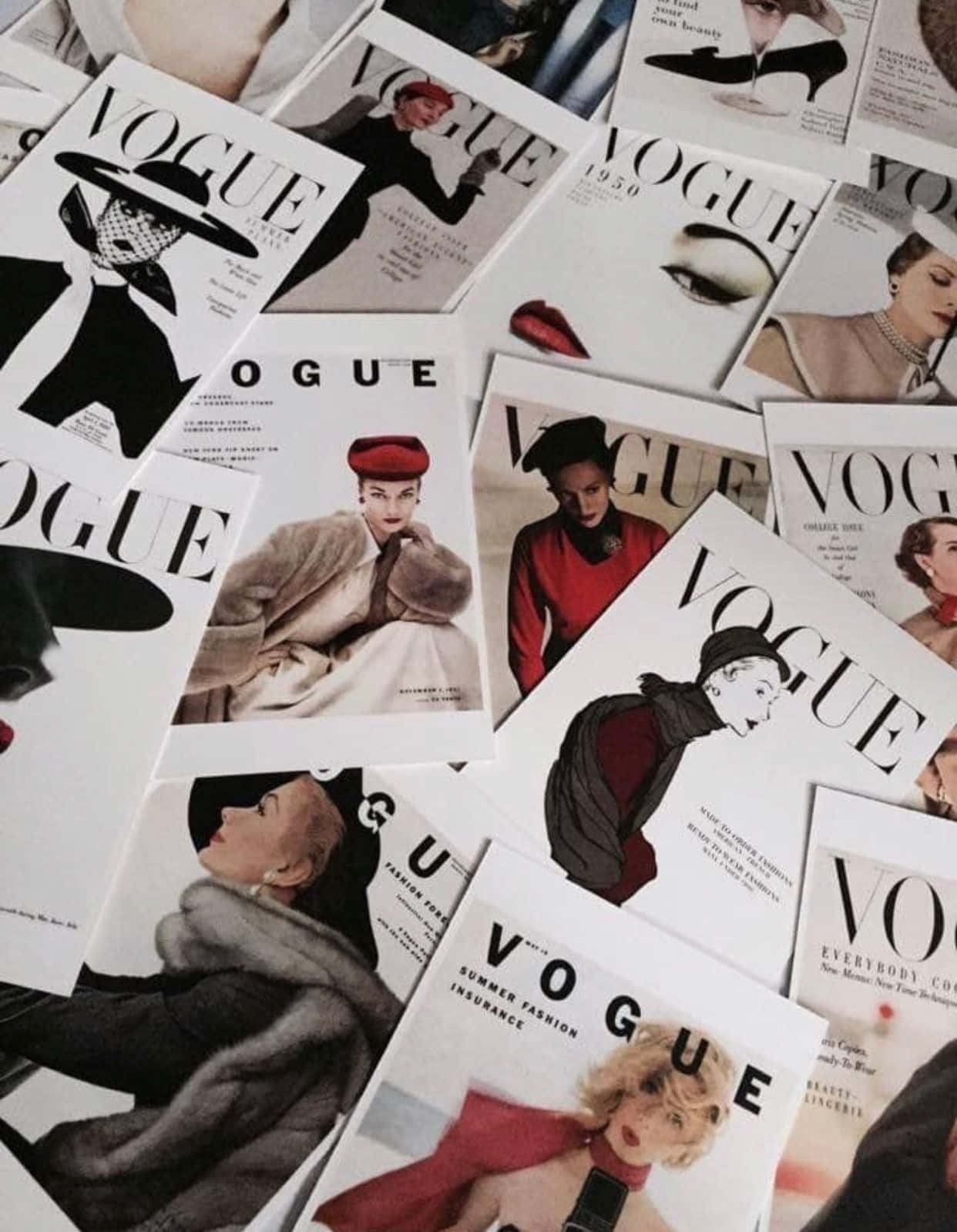 雜誌 桌布 壁紙 — 一堆散落的復古Vogue雜誌封面，展示經典時尚攝影中的迷人女性。