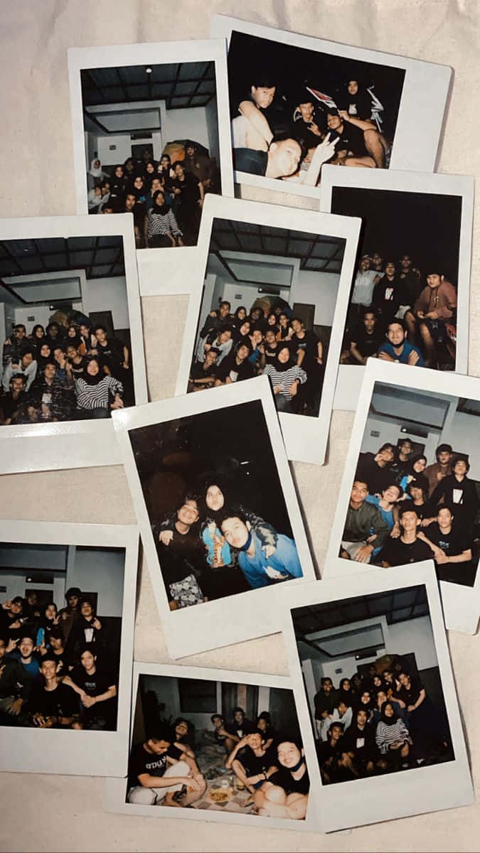 Aesthetic Polaroid 桌布 壁紙 — 一堆散落的拍立得照片捕捉了在昏暗室內環境中與微笑朋友一起的熱鬧聚會。