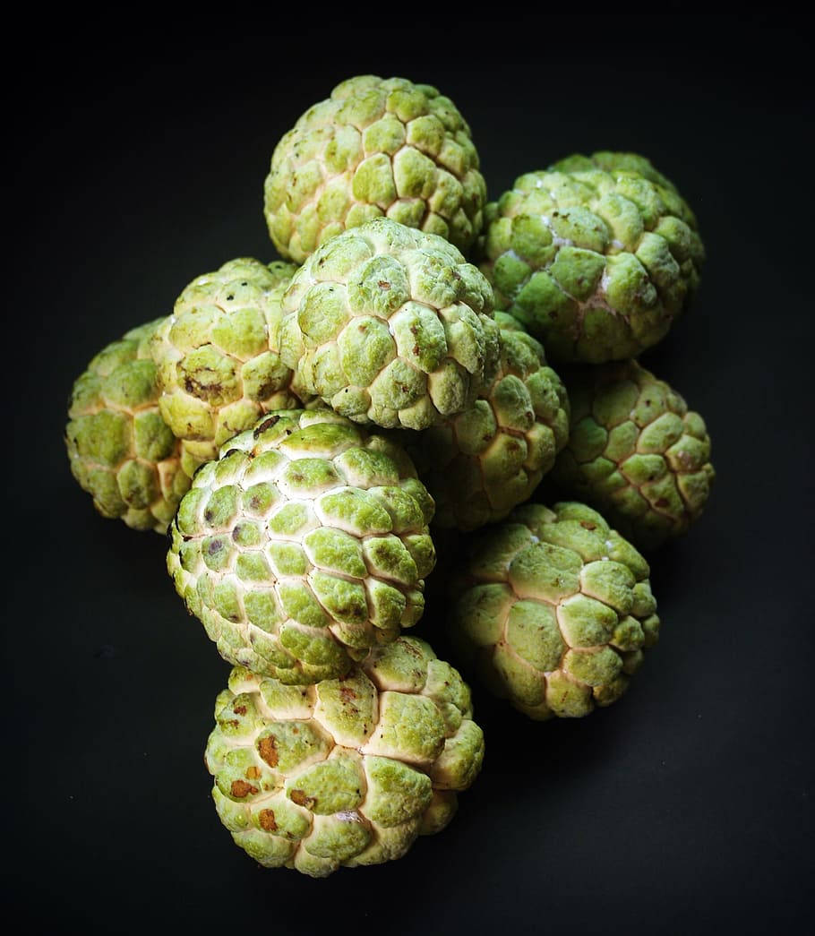 Fruit 桌布 壁紙 — 一堆新鮮的綠色刺果番荔枝，表皮帶有紋理，放在純黑色背景上。