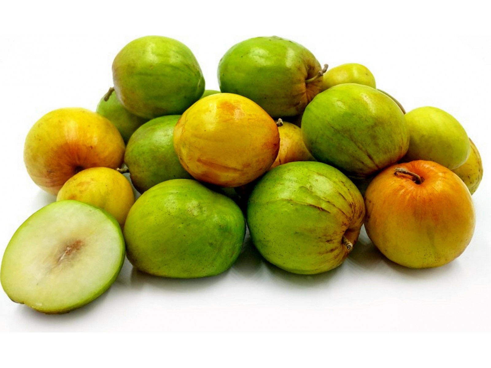 Fruits 桌布 壁紙 — 一堆新鮮的綠色和黃色棗子，其中一個切開，露出淡色的果肉，背景為白色。