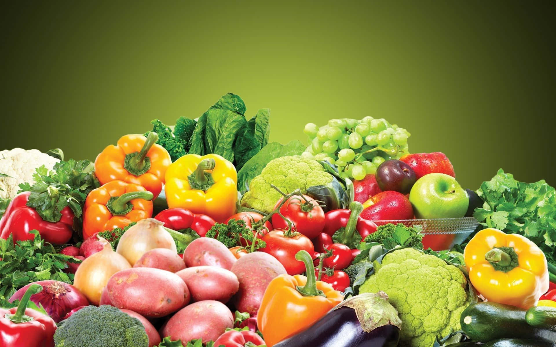 Vegetables 桌布 壁紙 — 一堆新鮮色彩繽紛的蔬菜和水果，包括甜椒、番茄、葡萄和花椰菜，在綠色漸變背景前。