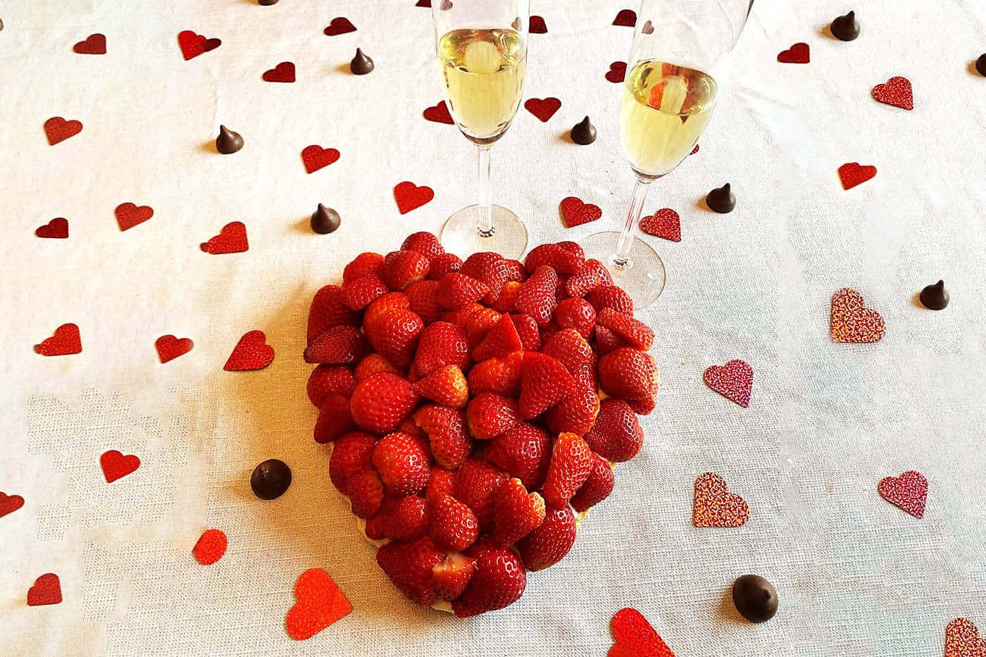 Strawberries 桌布 壁紙 — 一堆新鮮草莓堆成心形，放在兩個香檳杯之間，白色桌布上散落著紅色心形和巧克力之吻。